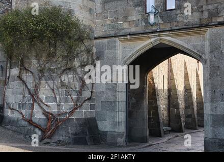 Fragment einer Wand mit Bogen und Turm von an Antiker Palast, der in Form einer mittelalterlichen Burg erbaut wurde Stockfoto