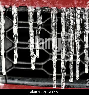 Schöne Eiszapfen auf dem Auto. Konzept für den Winter- und gefährlichen Winterverkehr von Autos auf der Straße. Stockfoto