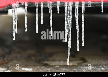 Schöne Eiszapfen auf dem Auto. Konzept für den Winter- und gefährlichen Winterverkehr von Autos auf der Straße. Stockfoto