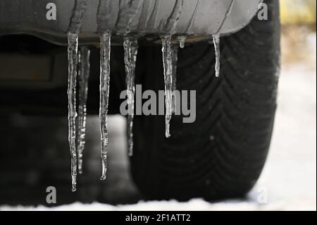 Schöne Eiszapfen auf dem Auto. Konzept für den Winter- und gefährlichen Winterverkehr von Autos auf der Straße. Stockfoto