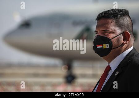 Bagdad, Irak. März 2021, 08th. Ein irakischer Sicherheitsbeamter, der eine Gesichtsmaske mit der irakischen und der Vatikanstadt aufgedruckten Flagge trägt, steht während der Abschiedzeremonie von Papst Franziskus am internationalen Flughafen Bagdad. Quelle: Ameer Al Mohammedaw/dpa/Alamy Live News Stockfoto