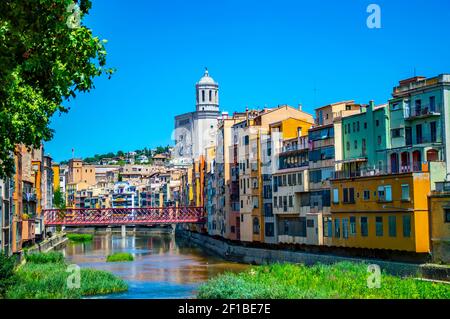 Girona, Spanien - 28. Juli 2019: Farbenfrohe Häuser des jüdischen Viertels von Girona mit der Eiffel Brücke und der Kathedrale Santa Maria im Hintergrund Stockfoto