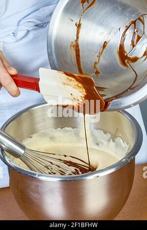 Cook bereitet Schokoladencreme für Kuchen Stockfoto