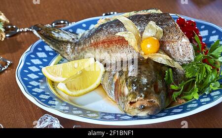 Gebratener gefüllter Fisch auf einer Platte festliches Menü Stockfoto