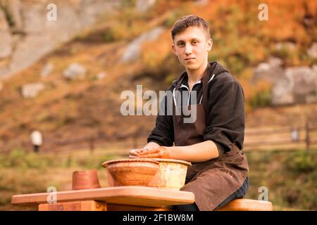 Man Töpfer arbeiten mit Tonwaren. Junger hübscher Mann Töpfer auf seiner Werkstatt. Stockfoto