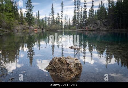 Bergsee spiegelt seine Umgebung wider, aufgenommen am Grassi Lakes Trail, Canmore, Alberta, Kanada Stockfoto