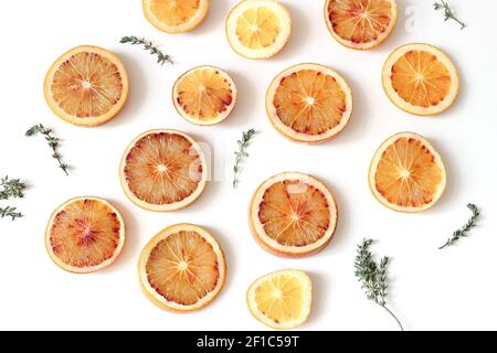 Nahaufnahme von frischen ganzen und schneiden blutigen Orangen mit Thymian Kraut isoliert auf weißen Tisch Hintergründe. Fruchtmuster. Food-Konzept. Sommerrahmen, w Stockfoto
