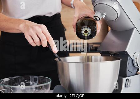 Frau, die Küchenmaschine benutzt, um in der Küche zu kochen Stockfoto