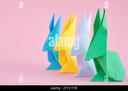 Papier bunte Origami Esser Kaninchen auf rosa Hintergrund. Konzept der Osterfeier Stockfoto