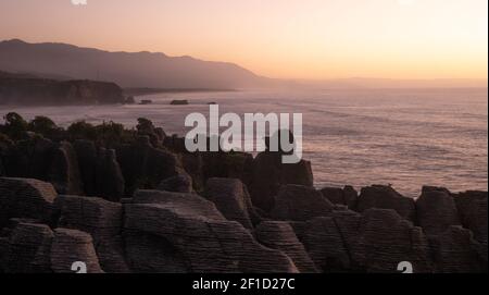 Ungewöhnliche Felsformationen an der Küste des Ozeans während Sonnenuntergang aufgenommen, Bild gemacht´s Punakaiki Pancake Rocks, Westküste, Neuseeland Stockfoto