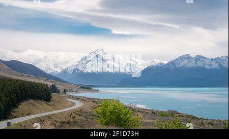 blick auf die Alpen mit türkisfarbenem See und Bergen (mit Mount Cook) im Hintergrund mit einer Autobahn, die zu ihnen führt, aufgenommen im Aoraki/Mt Cook National Park Stockfoto