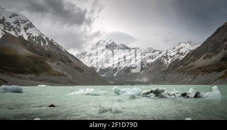 Sturm nähert sich in alpinem Gelände. Gletschersee mit Eisstücken und Bergen im Hintergrund, aufgenommen im Aoraki/Mt Cook National Park, Neuseeland Stockfoto