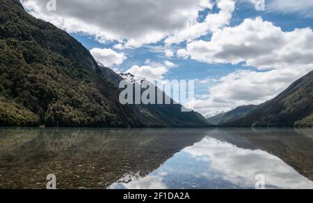 Spiegelungen auf einem See während eines sonnigen Tages. Foto aufgenommen am Lake Gunn, Fiordland National Park, Neuseeland Stockfoto