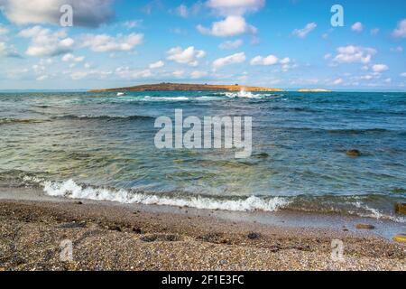 seeseite mit Insel in der Ferne. Schöne Landschaft von bulgarien in der Nähe von sozopol. Wellen krachend felsigen Ufer. Sonniges Wetter mit flauschigen Wolken auf Th Stockfoto