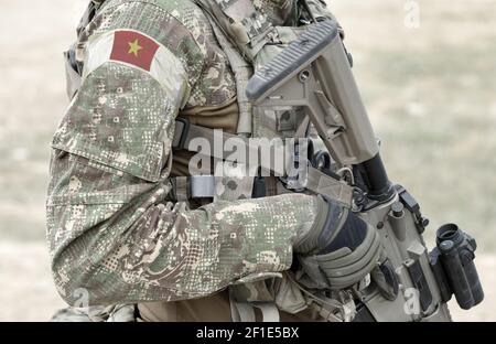 Soldat mit Sturmgewehr und Flagge Vietnams auf Militäruniform. Collage. Stockfoto