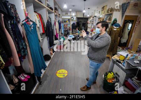 Gerry Keating, Store Manager von Vincent's an der Ormeau Road in Belfast, fotografiert Babyartikel, die auf der Facebook-Seite des Stores veröffentlicht werden. Die Society of St. Vincent De Paul Charity-Shop bietet einen Click and Collect-Service durch Fotografieren von Artikeln im Geschäft mit Kunden anzeigen Artikel über den Shop Facebook-Seite, und in der Lage, Kontakt und kaufen Artikel für die spätere Sammlung. Stockfoto