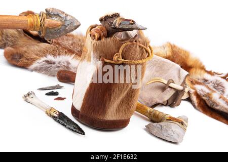 Steinzeit-Handtasche mit Cavemen Ax, Werkzeug und Messer auf weißem Hintergrund Stockfoto