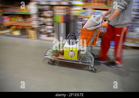 Dresden, Deutschland. März 2021, 08th. Ein Kunde schiebt einen beladenen Warenkorb in einem Hornbach-Baumarkt durch einen Gang. Ab heute dürfen Baumärkte in Sachsen nach wochenlanger Schließung aufgrund von Korona den Betrieb nach strengen Hygienevorschriften wieder aufnehmen. Quelle: Robert Michael/dpa-Zentralbild/dpa/Alamy Live News Stockfoto
