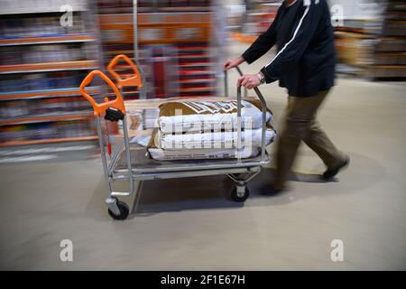 Dresden, Deutschland. März 2021, 08th. Ein Kunde schiebt einen beladenen Warenkorb in einem Hornbach-Baumarkt durch einen Gang. Ab heute dürfen Baumärkte in Sachsen nach wochenlanger Schließung aufgrund von Korona den Betrieb nach strengen Hygienevorschriften wieder aufnehmen. Quelle: Robert Michael/dpa-Zentralbild/dpa/Alamy Live News Stockfoto