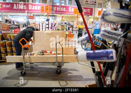 Dresden, Deutschland. März 2021, 08th. Ein Kunde schiebt einen beladenen Warenkorb in einem Hornbach-Baumarkt durch einen Gang. Ab heute dürfen Baumärkte in Sachsen nach wochenlanger Schließung aufgrund von Korona den Betrieb nach strengen Hygienevorschriften wieder aufnehmen. Quelle: Robert Michael/dpa-Zentralbild/dpa/Alamy Live News Stockfoto