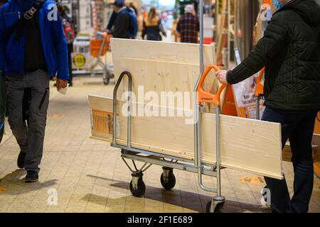 Dresden, Deutschland. März 2021, 08th. Ein Kunde schiebt einen beladenen Warenkorb in einem Hornbach-Baumarkt durch einen Gang. Ab heute dürfen Baumärkte in Sachsen nach wochenlanger Schließung aufgrund von Korona den Betrieb nach strengen Hygienevorschriften wieder aufnehmen. Quelle: Robert Michael/dpa-Zentralbild/dpa/Alamy Live News Stockfoto