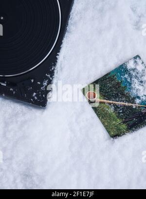 Direkt über Plattenspieler und 45 U/min Vinyl Schallplattencover im Schnee. Konzept von Retro, Nostalgie, gestern, Stockfoto