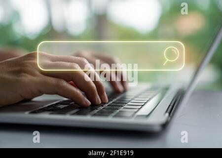 Menschen Hand mit Laptop oder Computer Suche nach Informationen im Internet Online-Gesellschaft Web mit Suchfeld Symbol und Copyspace. Stockfoto