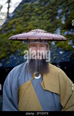 Europäischer Mann mit Bart meditiert in traditionellem, japanischem Shugendo-Outfit im Freien Stockfoto