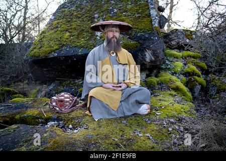 Europäischer Mann mit Bart meditiert in traditionellem, japanischem Shugendo-Outfit im Freien Stockfoto