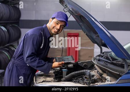 Porträt des Mechanikers, der mit seinem digitalen Tablet arbeitet automatische Reparatur Stockfoto