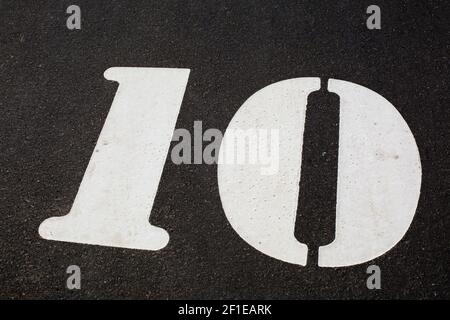 Eine weiße Nummer auf dem schwarzen Asphalt Stockfoto