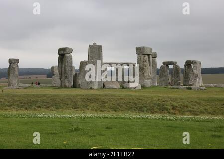 Stonehenge, Salisbury Plain, Wiltshire, England, UK Es besteht aus einem äußeren Ring von vertikalen Sarsen stehenden Steinen, jeweils rund 13 Meter hoch, sieben Meter breit und ein Gewicht von rund 25 Tonnen, gekrönt durch die Verbindung horizontalen Sturzsteine. Besucher schauen sich an einem trüben Sommertag um die Steine Stockfoto