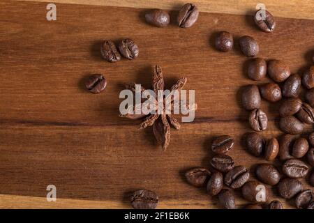 Sternanis und geröstete Kaffeebohnen auf einem Holztisch. Perfekte Kombination. Stockfoto