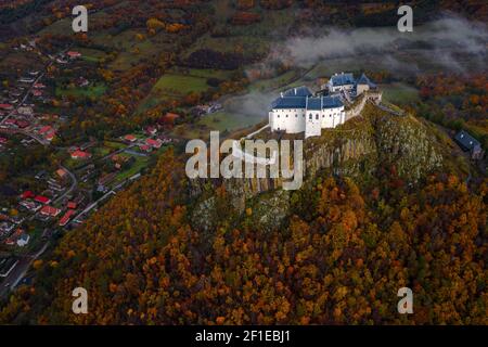 Fuzer, Ungarn - Luftaufnahme der schönen Burg von Fuzer auf einem Hügel mit bunten Herbstlaub an einem nebligen Morgen. Die Burg wurde lokalisiert Stockfoto