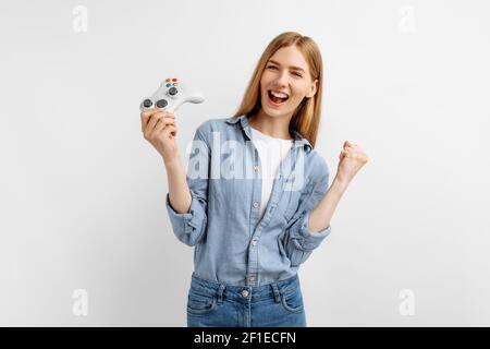 Glückliche junge Frau, die Videospiele spielt und den Sieg feiert Isolierter weißer Hintergrund Stockfoto