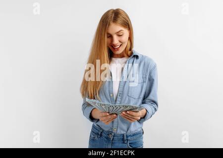 Glückliche junge zielgerichtete Frau, die Geld über isolierten weißen Hintergrund, Wirtschaftskonzept, Geldverteilung zählt Stockfoto