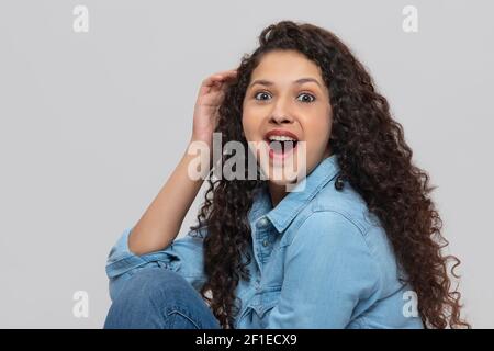 EIN TEENAGER-MÄDCHEN, DAS ÜBERRASCHT DIE KAMERA ANSCHAUT Stockfoto