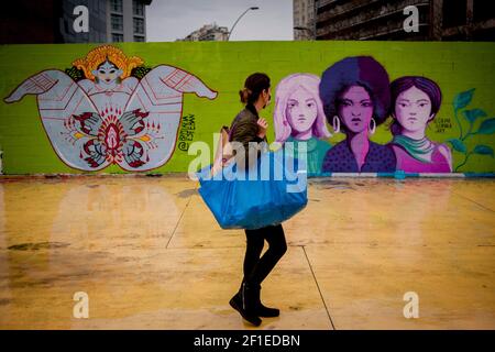 8. März 2021, Barcelona, Katalonien, Spanien: An diesem 8. März 2021 Internationalen Frauentag geht eine Frau mit Gesichtsmaske an Graffiti-Wandmalereien vorbei, die feministische Rechtsindikationen in Barcelona darstellen. Quelle: Jordi Boixareu/Alamy Live News Stockfoto