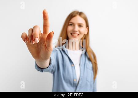 Attraktive junge Frau drücken virtuelle Taste über isolierten weißen Hintergrund Stockfoto