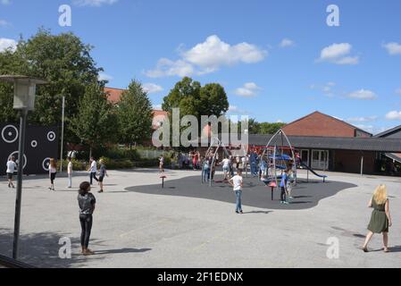 Eine große Gruppe von Kindern spielen auf dem Spielplatz während Schulpause Stockfoto
