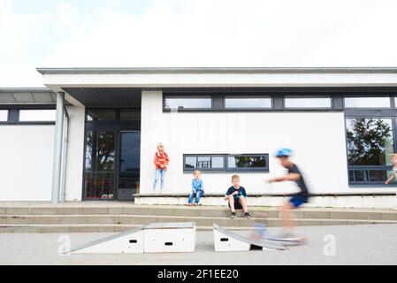 Kinder scooting während der Pause in einem Skater-Park in der Schule Stockfoto