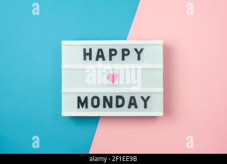 Happy Monday - Text auf Display Leuchtkasten auf blauem und pinkem Hintergrund. Stockfoto