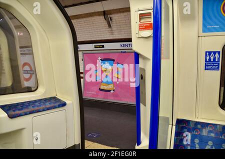 Passagiere und covid 19 Pandemie Gesicht Abdeckung und soziale Distanzierung Schilder auf die londoner U-Bahn-Züge 2021 Stockfoto