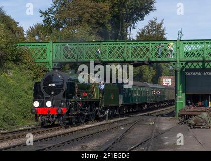 Eine Dampfeisenbahn fährt unter der Harry Potter Brücke im Ropley Staion auf der Mid Hants Watercress Linie Heritage Railway. Die Brücke befand ursprünglich ein Stockfoto