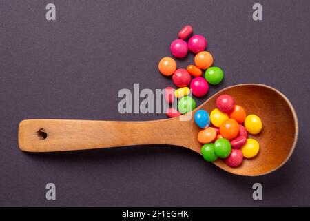 Mehrfarbiges Bonbon-Set mit einem Holzlöffel Stockfoto
