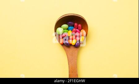 Mehrfarbiges Bonbon-Set mit einem Holzlöffel Stockfoto