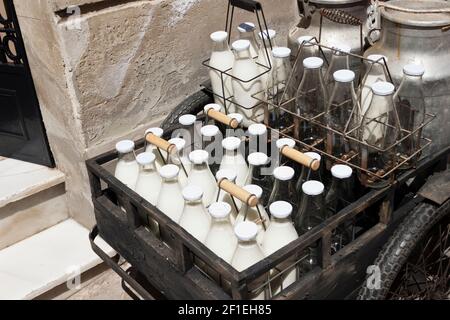 Flaschen und Aluminiumdosen Milch für die Lieferung in vintage rostigen Milchmann Fahrrad. Stockfoto