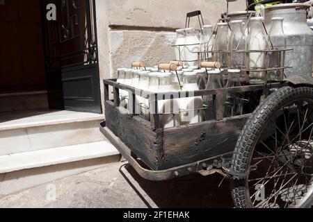 Flaschen und Aluminiumdosen Milch für die Lieferung in vintage rostigen Milchmann Fahrrad. Stockfoto