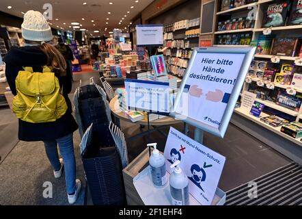 Leipzig, Deutschland. März 2021, 08th. Ein Kunde kommt an einem Schild vorbei, auf dem steht: „Bitte desinfizieren Sie hier Ihre Hände!“ In eine Leipziger Buchhandlung. Ab diesem Montag können Buchhandlungen unter bestimmten Bedingungen wieder geöffnet werden. Quelle: Hendrik Schmidt/dpa-Zentralbild/ZB/dpa/Alamy Live News Stockfoto