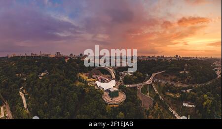 Panoramablick auf Kiew vom Himmel. Sonnenuntergang über Sommer Kiew mit Bogen der Freundschaft der Völker. Gefilmt auf Drohne. Luftaufnahme Stockfoto